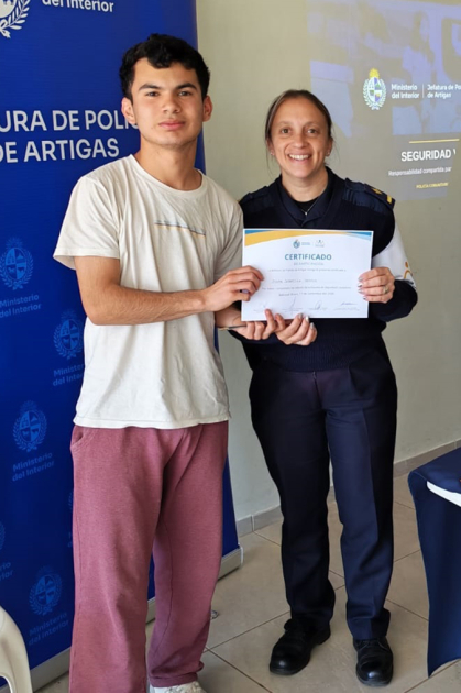 Sub Comisario Natalia Pacheco entregando certificado a participante en Baltasar Brum