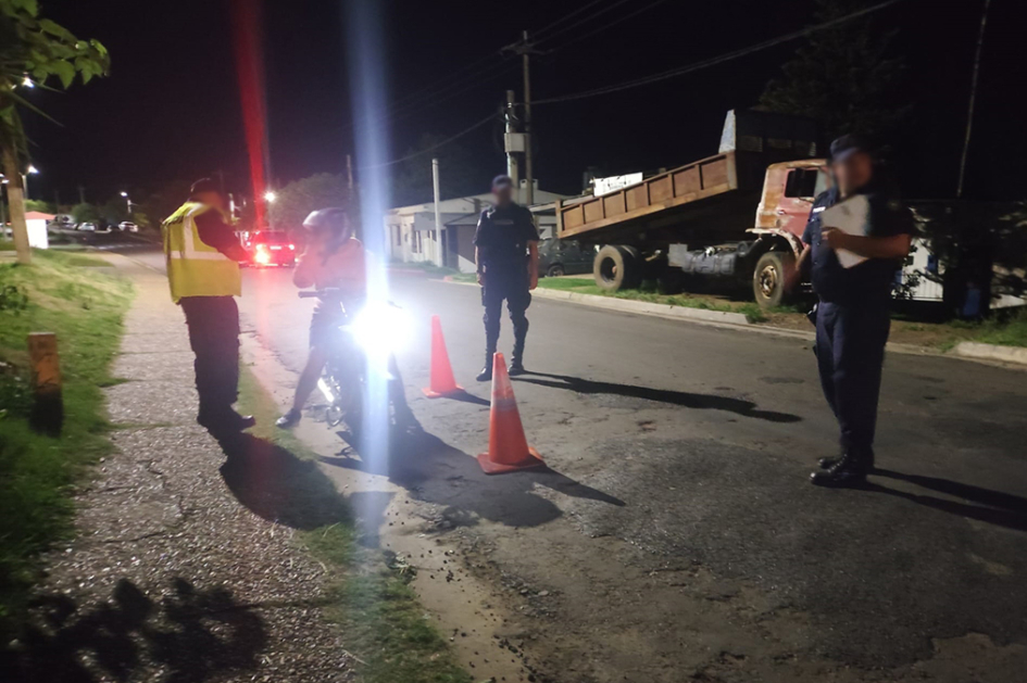 Tres policías inspeccionando a un motociclista Tres policías inspeccionando a un motociclista