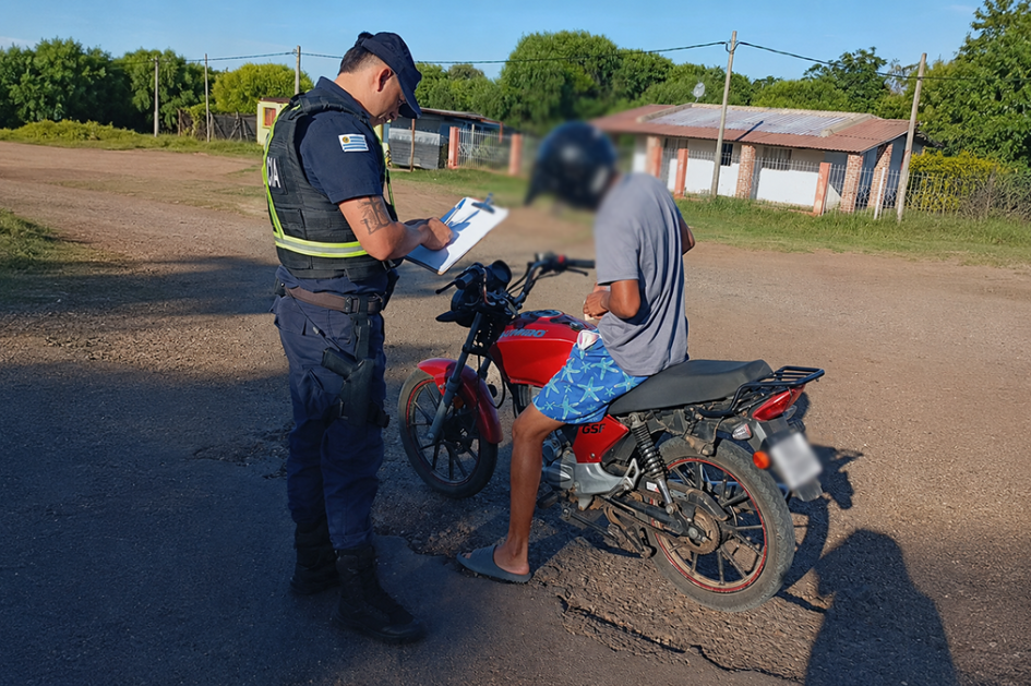Un hombre en moto siendo inspeccionado por la policía Un hombre en moto siendo inspeccionado por la policía