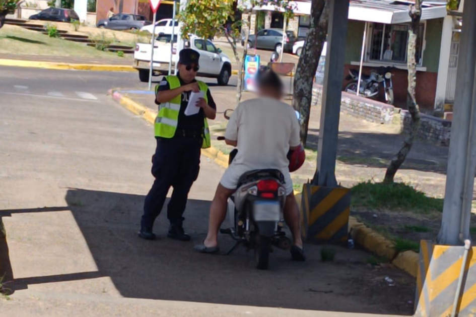 Una persona en una motocicleta y un policial controlando en cabecera del Puente de la Concordia