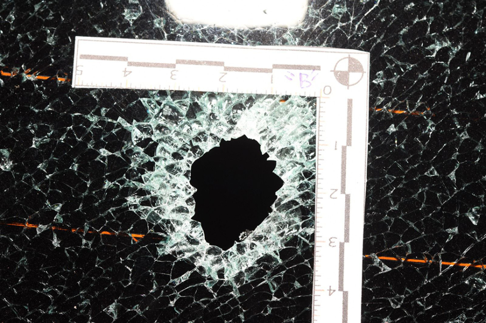 Vidrio de automóvil con orificio de proyectil.