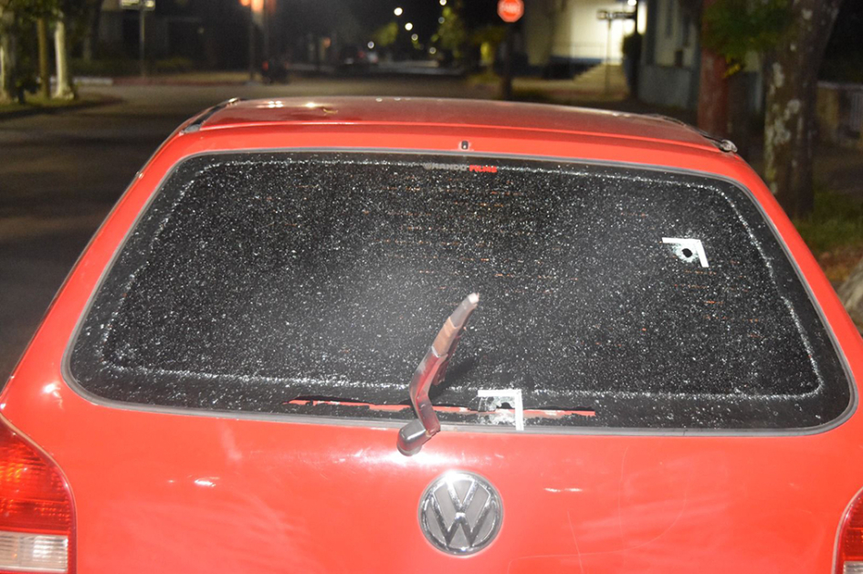 Vidrio trasero de automóvil con orificio de proyectil de arma de fuego.