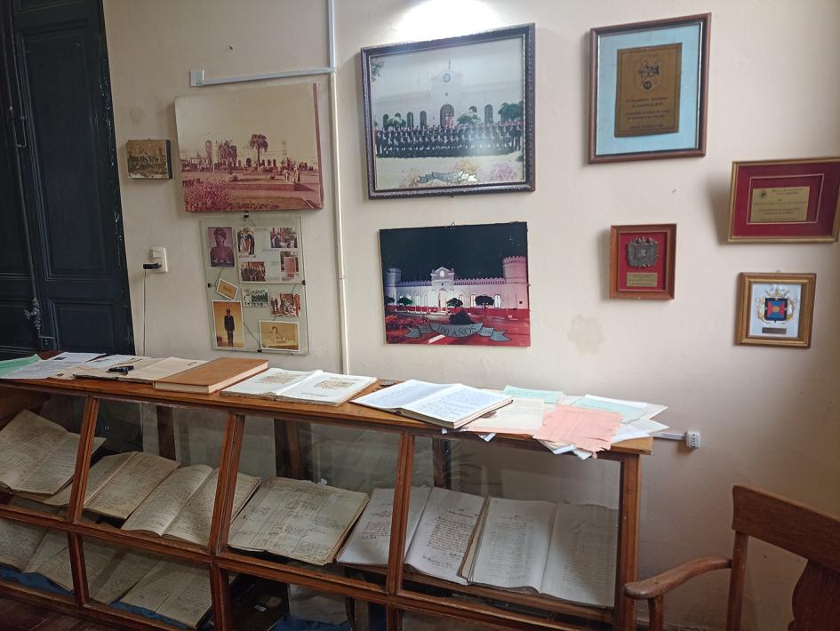 Vitrina con documentos y cuadros con fotografías