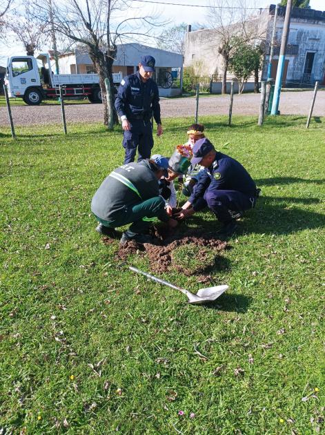 Policías niños plantan un árbol Policías y un niño plantan un árbol