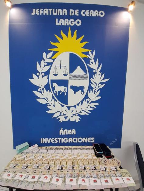 Logo del Área de Investigaciones y dinero incautado por parte del personal policial. Logo del Área de Investigaciones y dinero incautado por parte del personal policial.