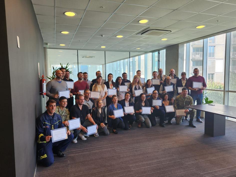 Fotografía grupal con certificado de aprobación. Fotografía de todos los participantes agachados