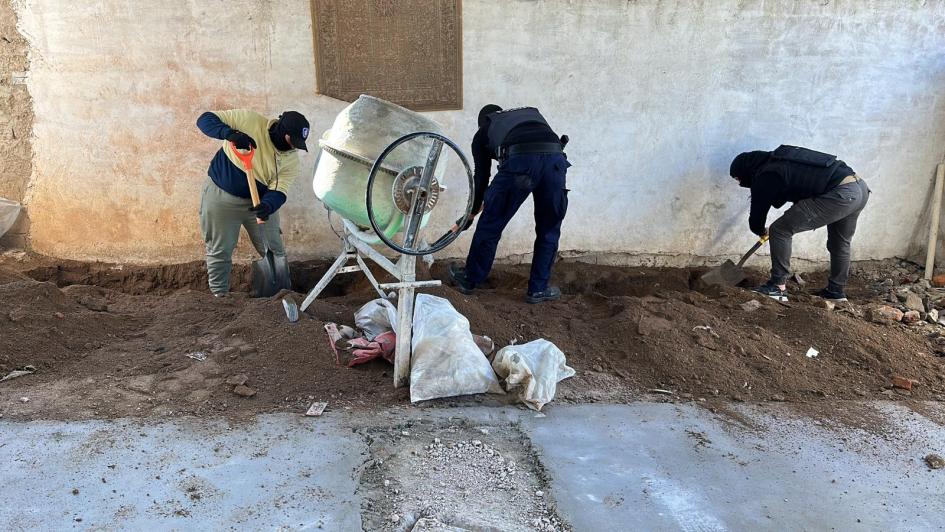 Policías de Drogas desenterrando los ladrillos de estupefacientes Policías desterrando los envoltorios