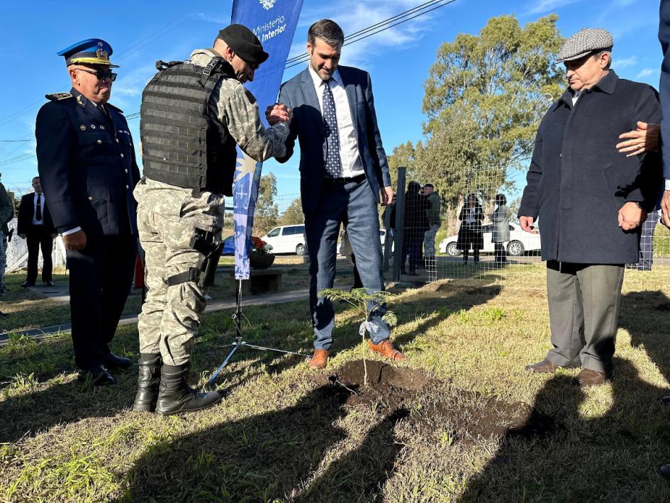 Ministro del interior con Policía beneficiario saludándose 