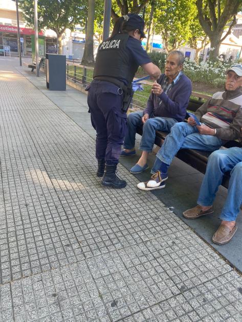 Policía entregando folletos a adultos mayores en vía pública