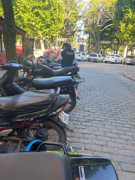 Policía colocando folletería en motos estacionadas