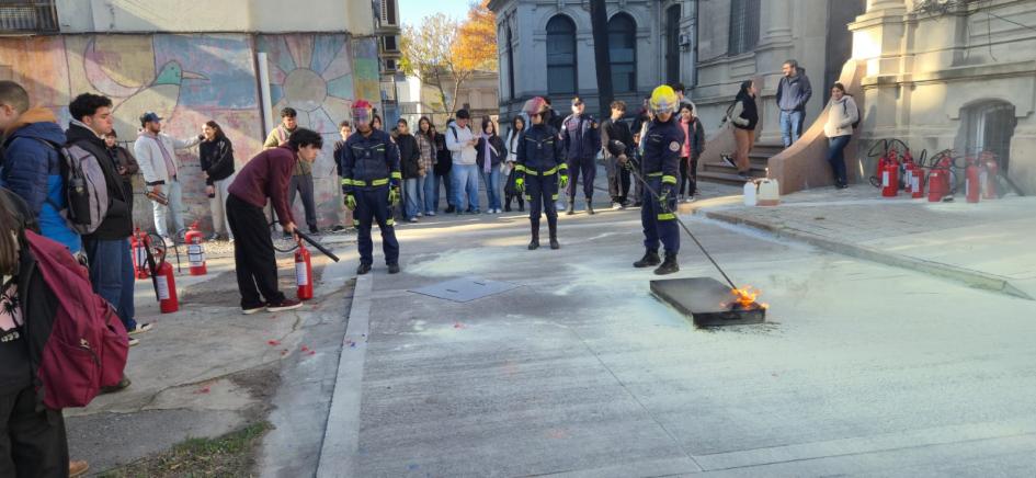 Capacitación práctica Estudiantes realizando la extinción del fuego en una bandeja de metal