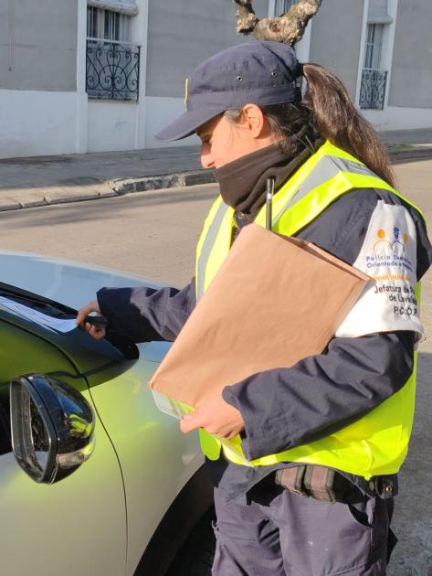 Policía colocando folleto Policía colocando folleto