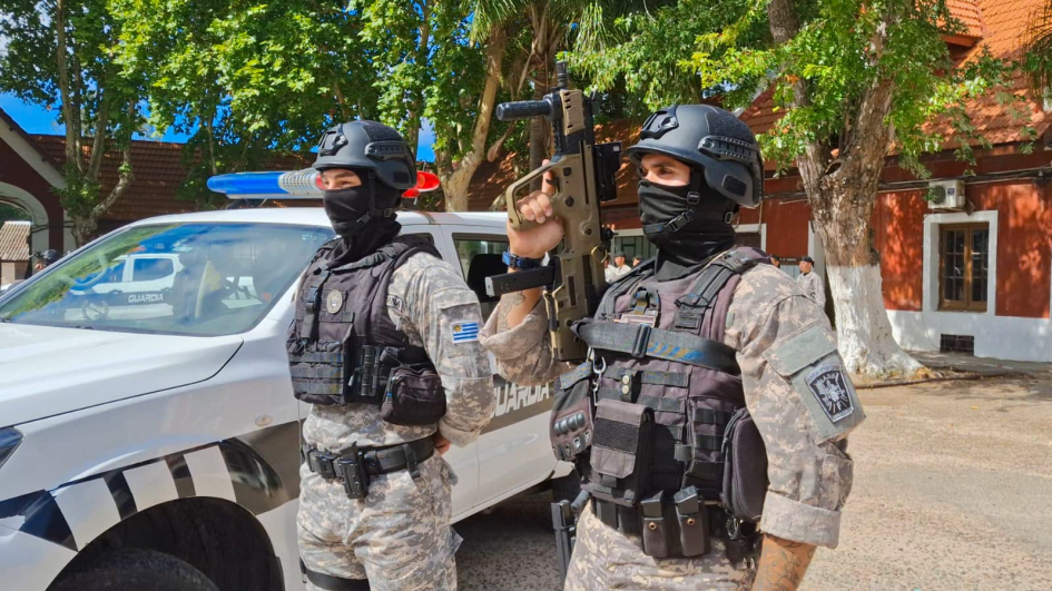 Policías de la Unidad PUMA de pie junto al móvil, con arma larga