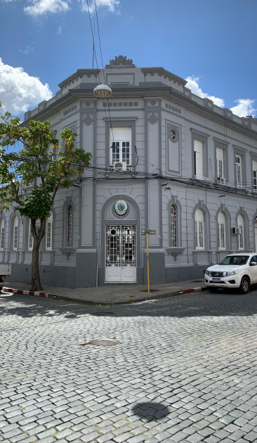 Fachada del edificio del Área de Investigaciones en Mercedes, esquina adoquinada y cielo despejado