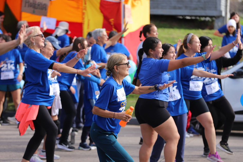 Personas de pie realizando el calentamiento guiado