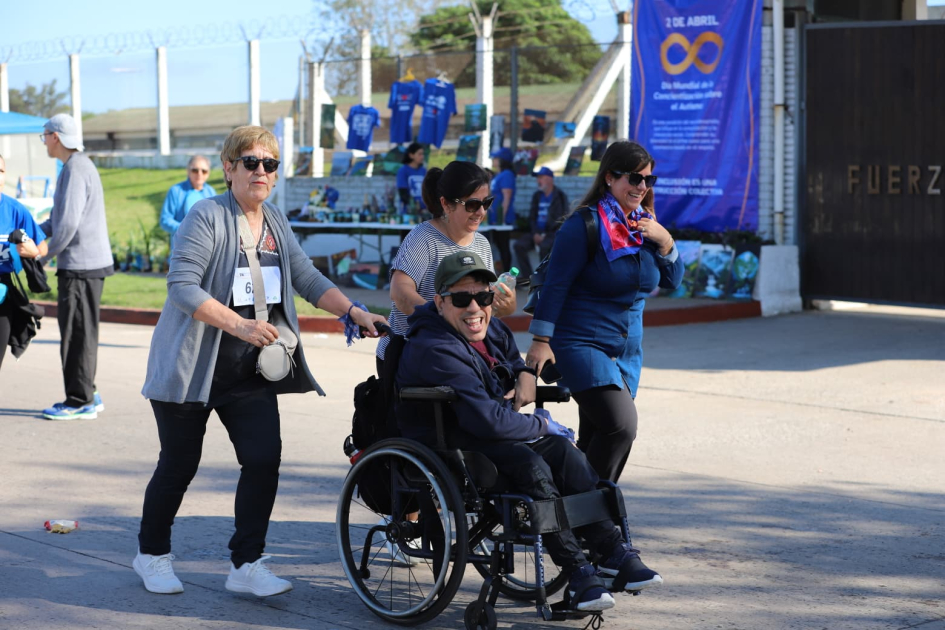 Participante con silla de ruedas y acompañantes llegando a la linea de meta