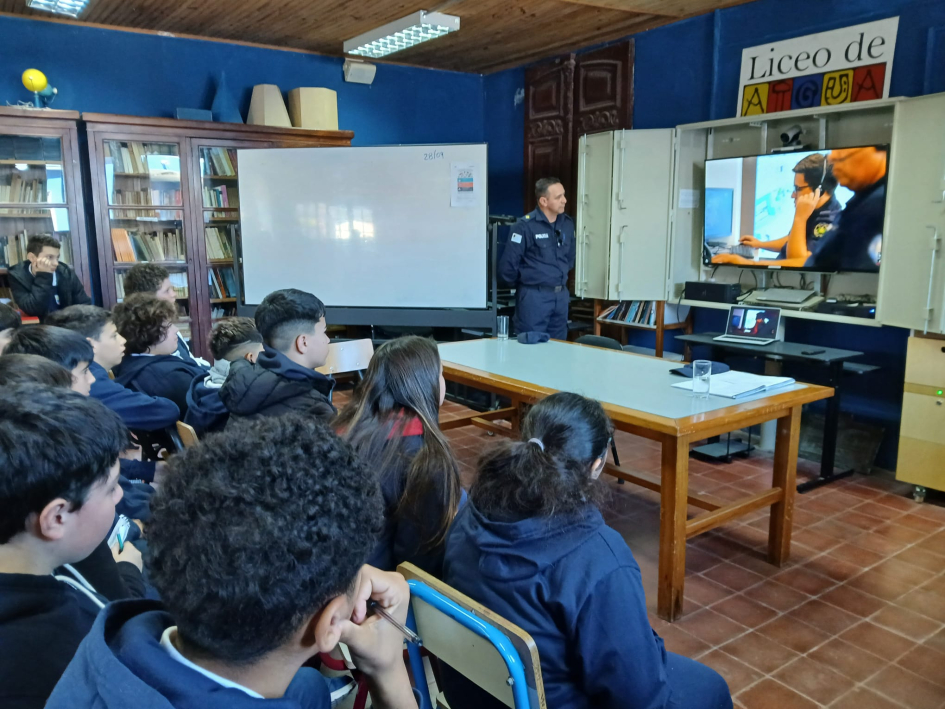 ALumnos escuchan al Oficial Delgado, encargado de la seccional de Aiguá.