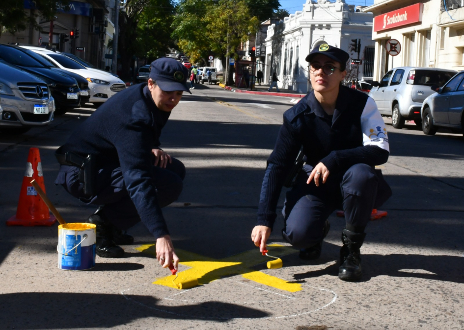 Policías pintando un lazo amarillo en el piso