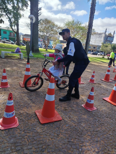 Niña en bicicleta con Policía en el circuito Niña en bicicleta con Policía en el circuito