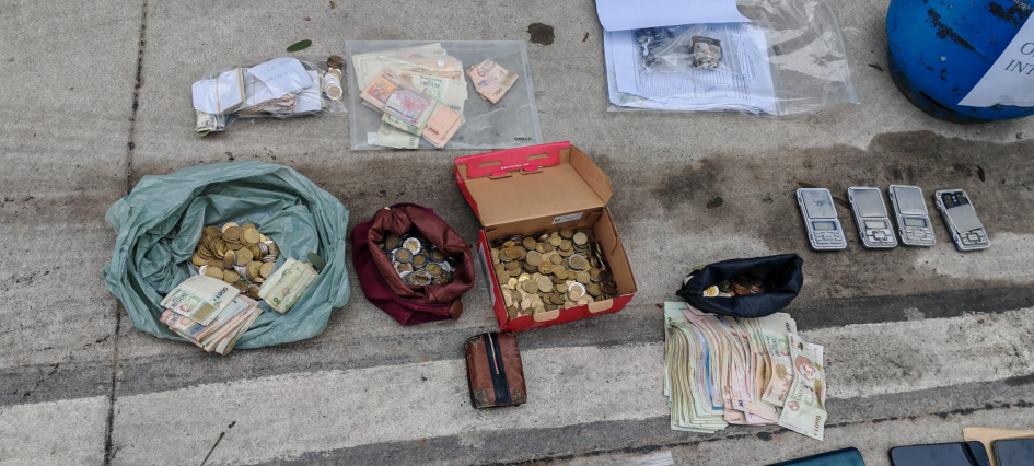 Cajas y bolsas con dinero, y balanzas de precisión en la vereda