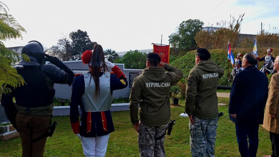 Autoridades y funcionariado DNGR rindiendo honores en Memorial del Caballo Autoridades y funcionariado DNGR de espalda haciendo saludo policial al Memorial del Caballo