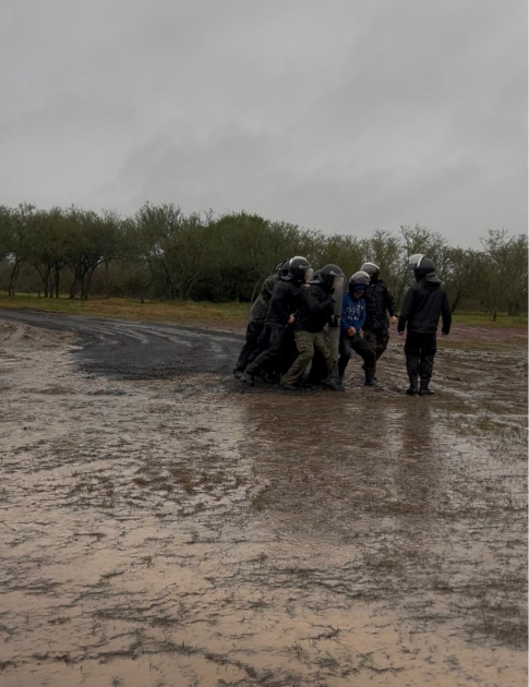 Funcionarios del curso ejecutan un ejercicio de desplazamiento y control antidisturbios bajo lluvia 