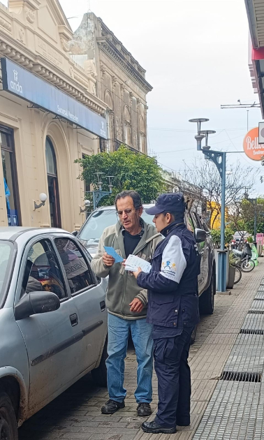 Policía entregando folleto Policía entregando folleto