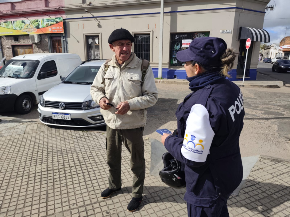 Policía entregando folleto Policía entregando folleto