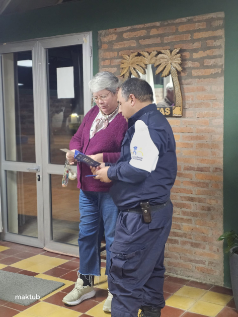 Policía entregando un folleto informativo a participante Policía entregando un folleto informativo a participante
