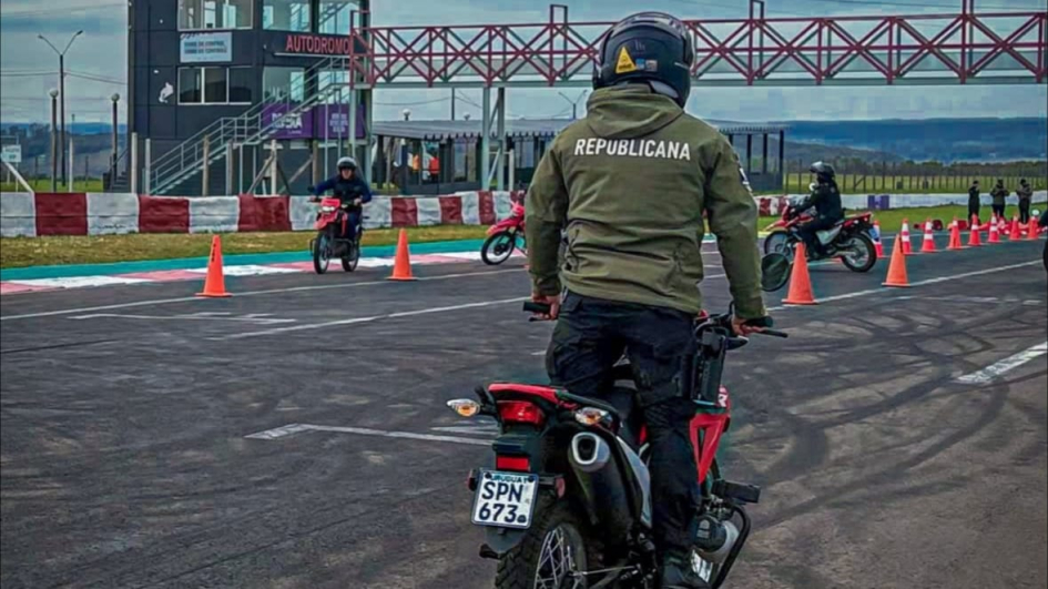 Vista trasera de un Instructor en moto con campera de la DNGR en una pista de maniobras.