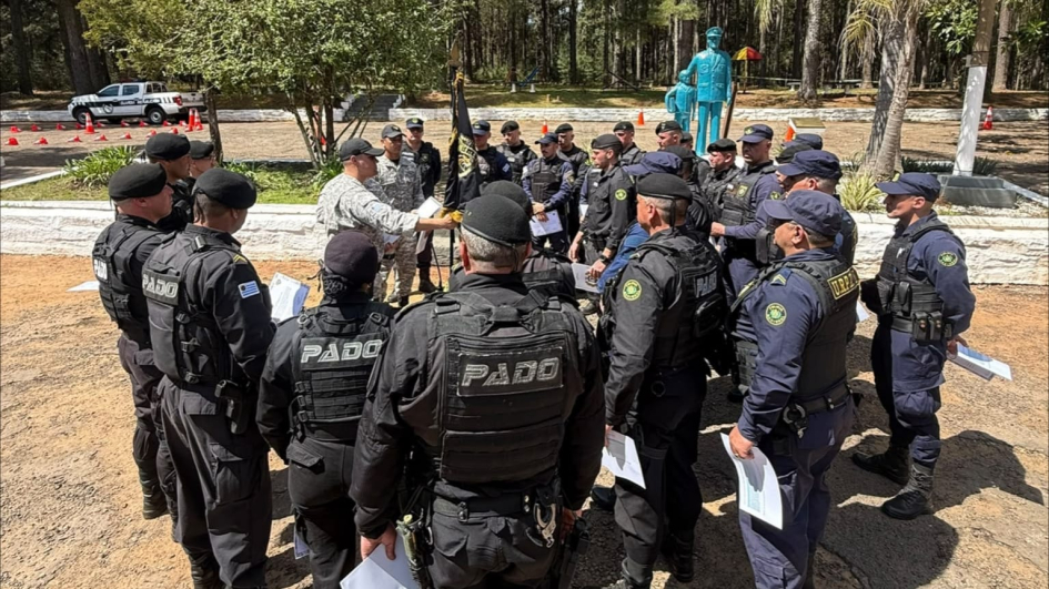 Grupo de policías formados en círculo al aire libre escuchando instrucciones.