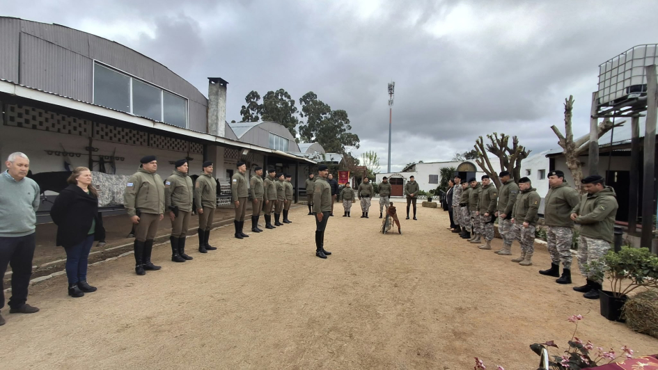 Vista general de ceremonia Dos filas de efectivos uniformados enfrentadas en patio al aire libre.
