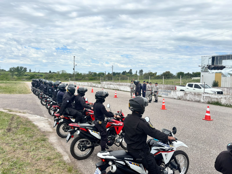 Policías uniformados sobre motocicletas formados en línea durante un entrenamiento al aire libre