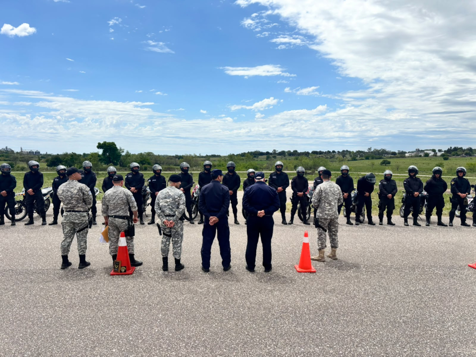Oficiales de la DNGR y JP Paysandú frente a una fila de agentes motorizados en campo abierto