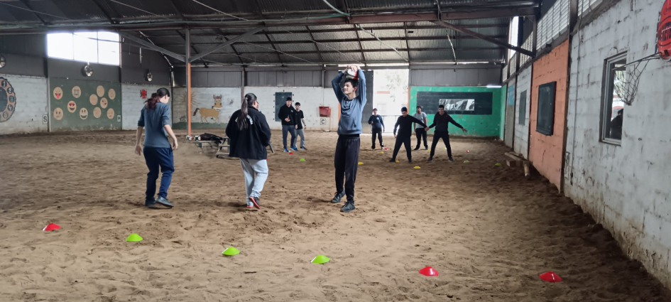 Dinámica con pelota en el picadero Alumnos realizando ejercicios de coordinación y lanzamiento de balón entre conos