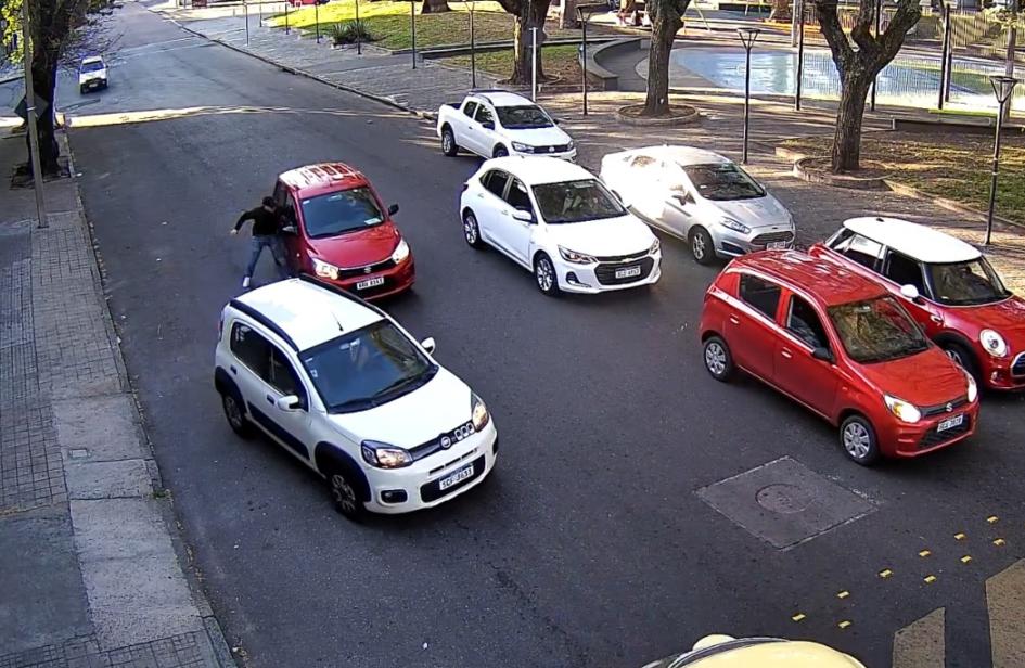 imagen del ladrón rompiendo el vidrio del auto