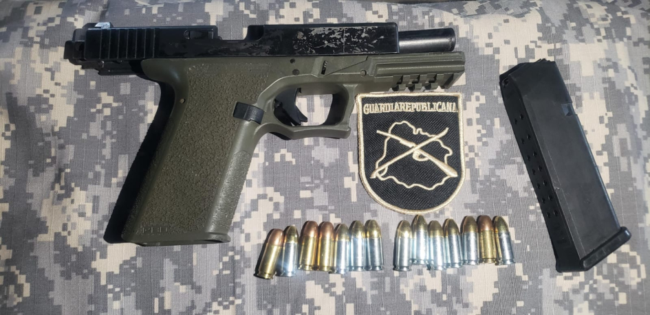 Pistola, cargador y municiones incautadas junto a emblema de la Guardia Republicana. Pistola, cargador y municiones incautadas junto a emblema de la Guardia Republicana.