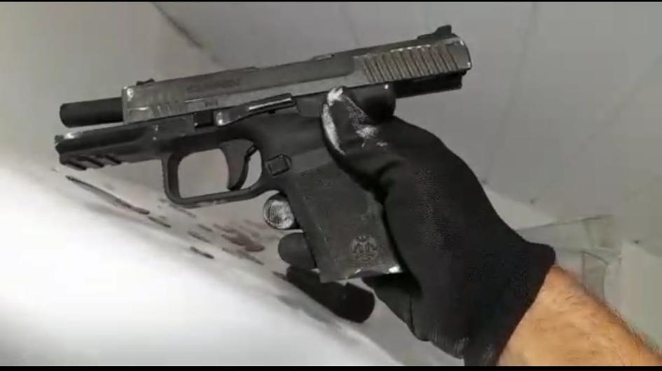 Formalizados por secuestro de una mujer en Maldonado una mano con un guante de color negro, sosteniendo un arma