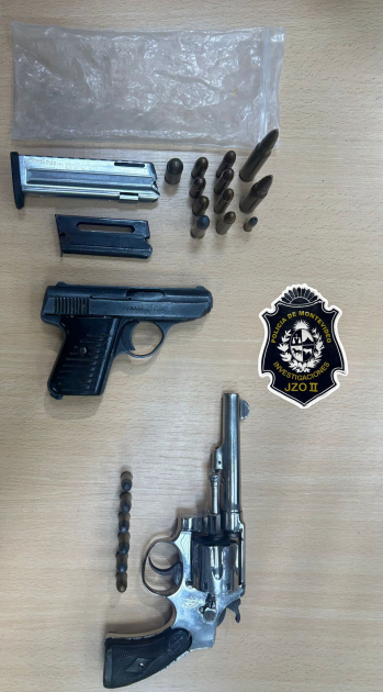 Armas y municiones incautadas exhibidas sobre una mesa 