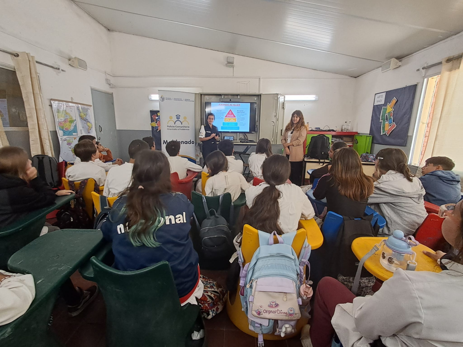 Alumnos escuchando a la oficial dando una charla en el salon de la escuela 96