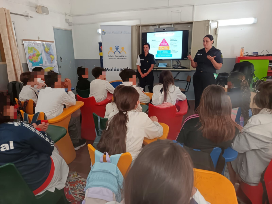 Alumnos escuchando a la oficial dando una charla en el salon de la escuela 96