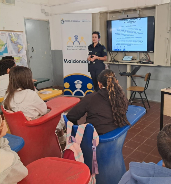 Alumnos escuchando a la oficial dando una charla en el salon de la escuela 96