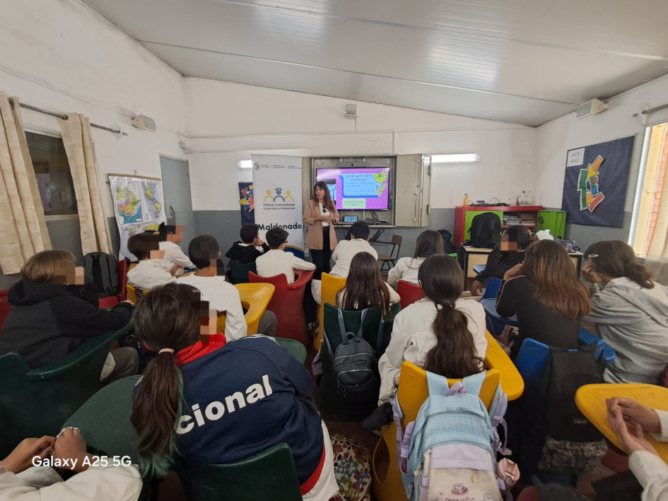 Alumnos escuchando a la oficial dando una charla en el salon de la escuela 96