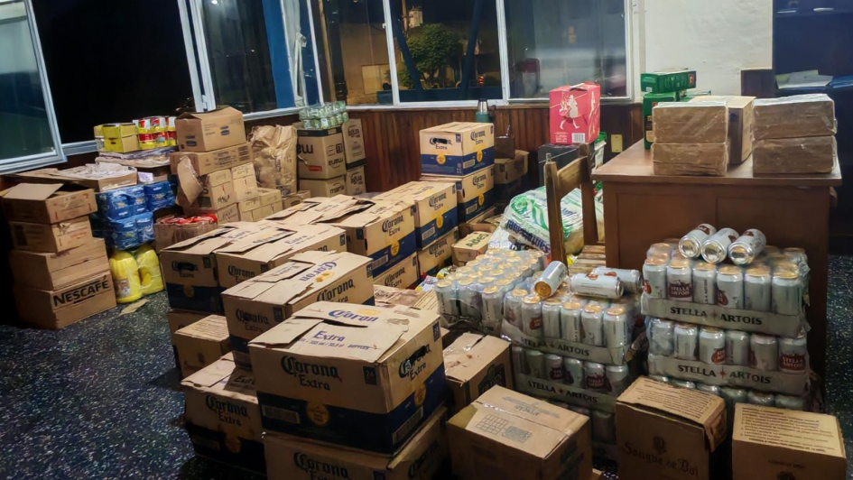 Gran cantidad de cajas y mercadería incautada apilada dentro de una oficina.