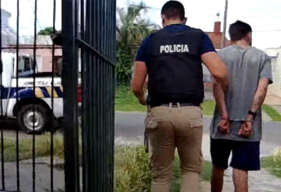 detenido esposado saliendo desde una vivienda