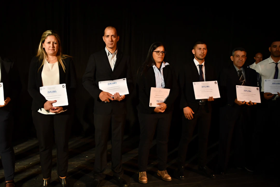 Celebración Día de la Policía Nacional policías mostrando su diploma en celebración realizada en Teatro Cantegril