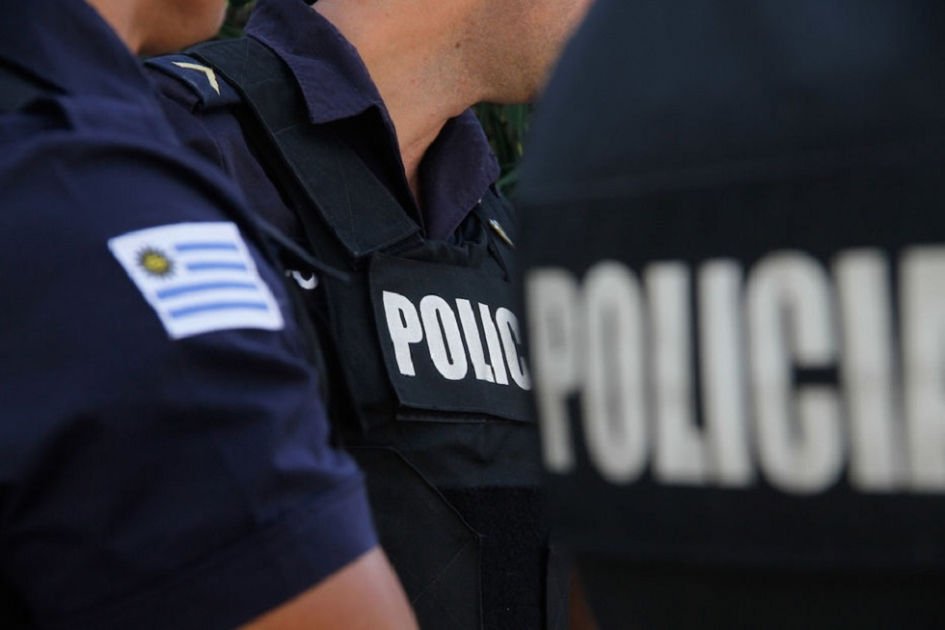 insigneas de policía y bandera de Uruguay en brazo y espalda de efectivos policiales