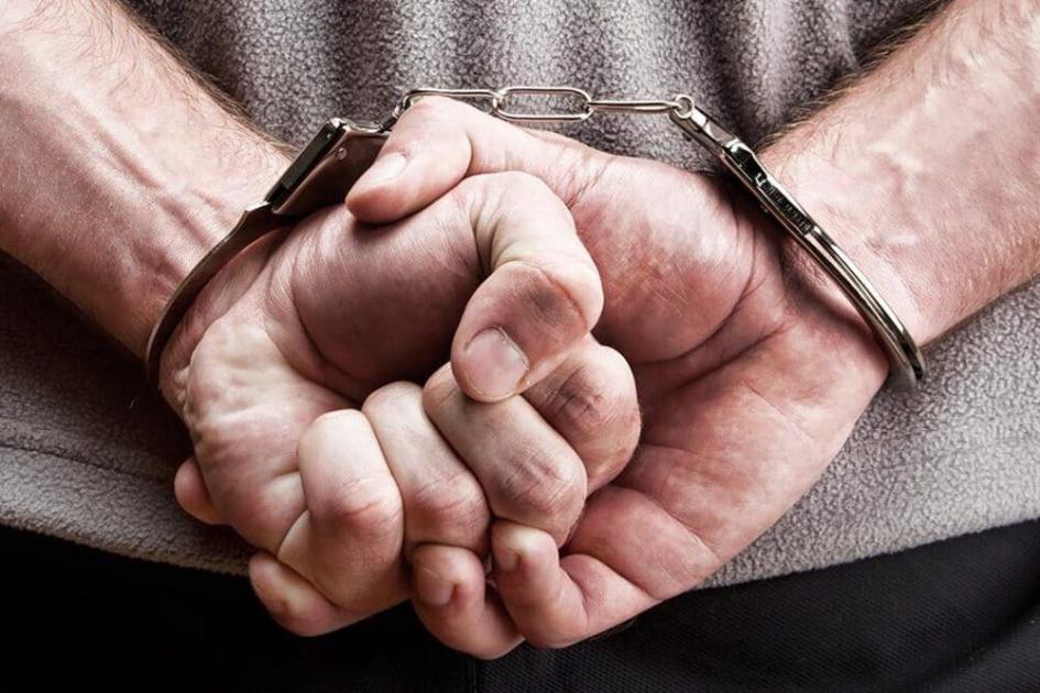 Hombre esposado de espaldas