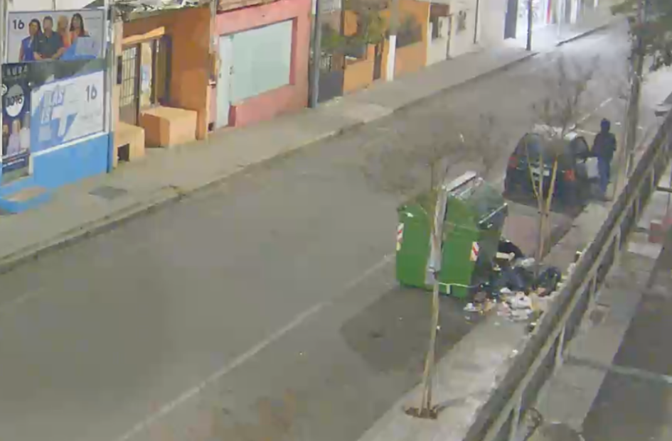 Momento del hurto en el vehículo Un hombre parado al costado de un auto con la puerta abierta