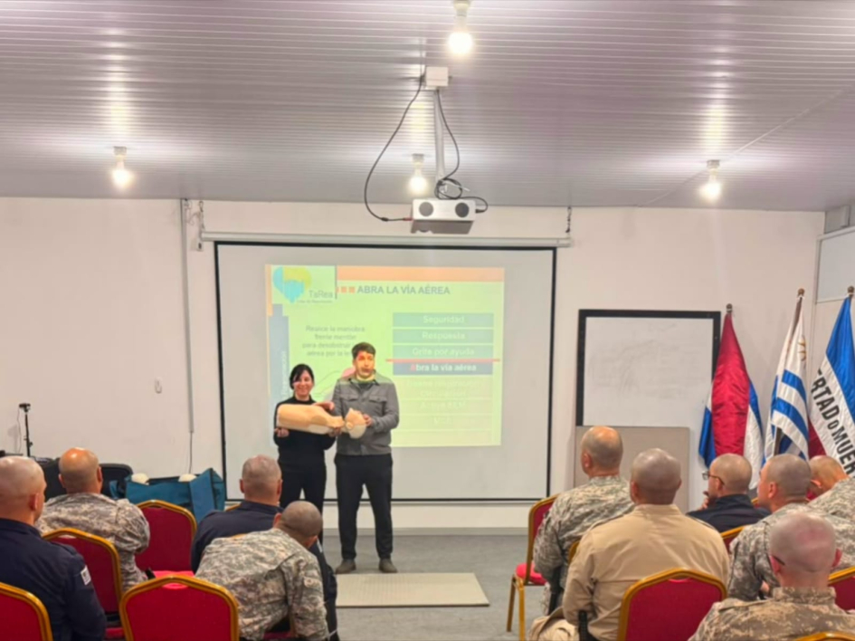 Presentación del Curso Reanimación Cardíaca Pulmonar Instructores del curso de pie frente a personal de la DNGR